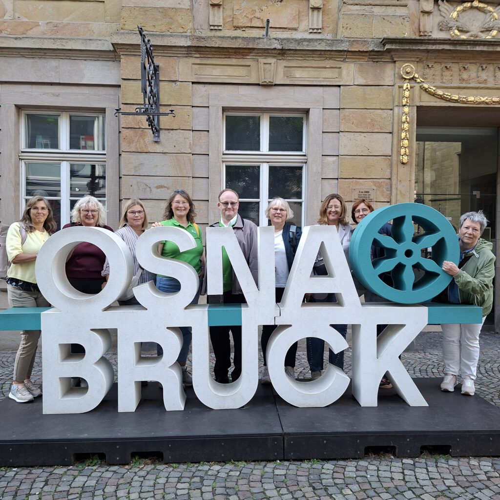 Logo der Stadt Osnabrück, dahinter stehen die Kolleg*innen aus den 4 Berufsverbänden.